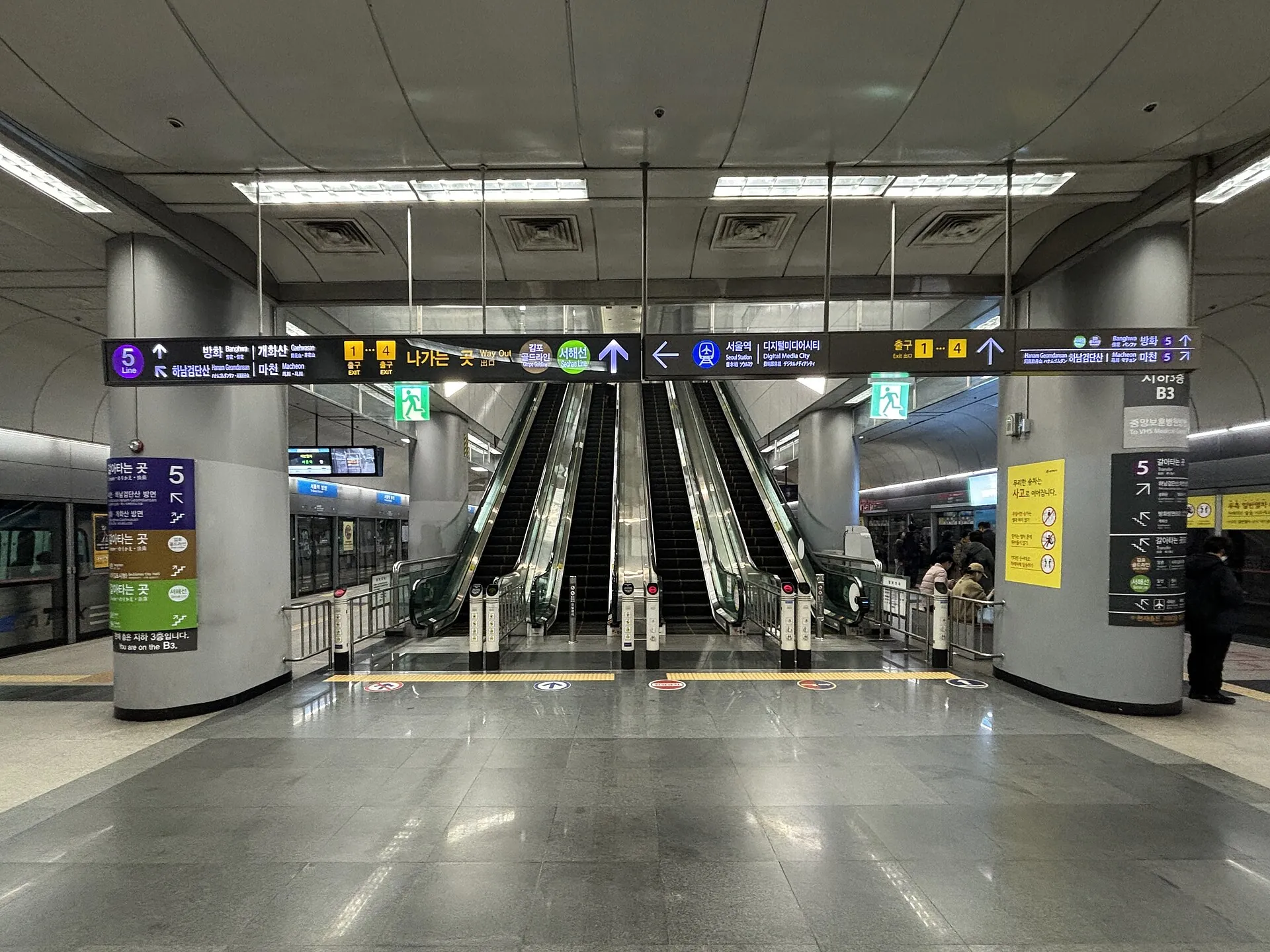 B3 shared platform: blue AREX signs and the Line 9 side beside the central escalator